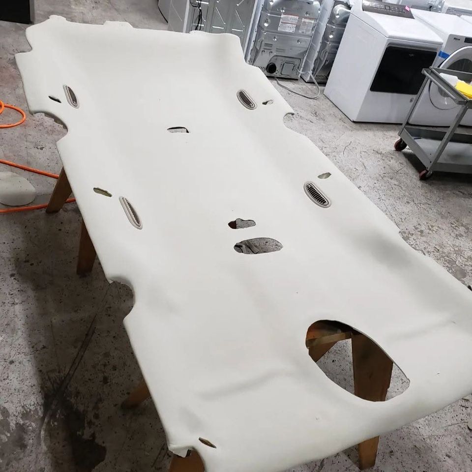 Headliner board after reupholstery, covered in new white fabric