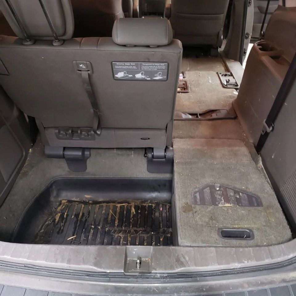 Honda Odyssey cargo area before interior detailing, with dirt and stains