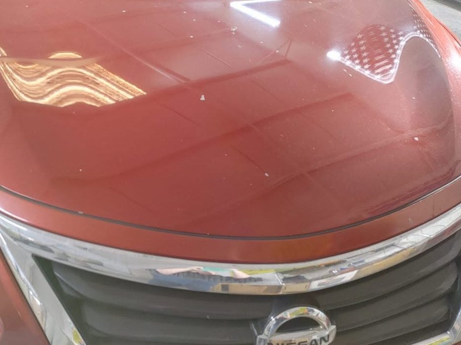 Nissan Altima hood with paint spots and haze before paint correction