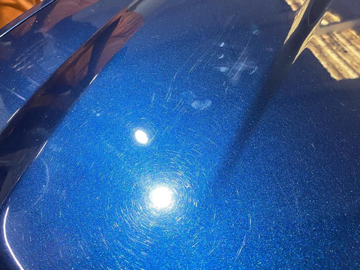 Blue hood with swirl marks and scratches before paint correction