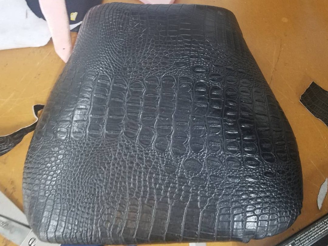 Seat recovered in black crocodile-pattern vinyl